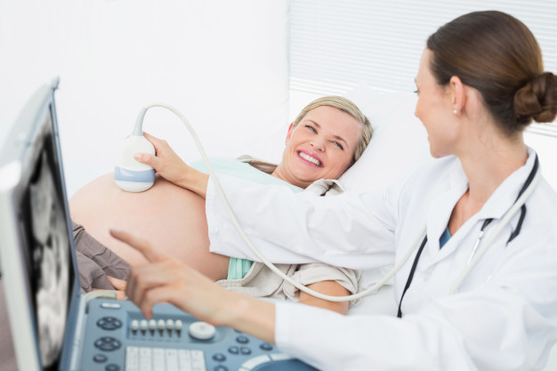 Les résultats de l'enquête échographique pour la femme enceinte sont sur  l'écran de l'appareil d'échographie, la femme au premier plan Photo Stock -  Alamy